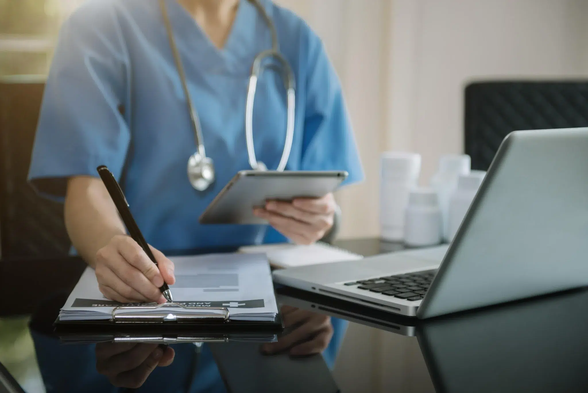doctor writing in front of laptop
